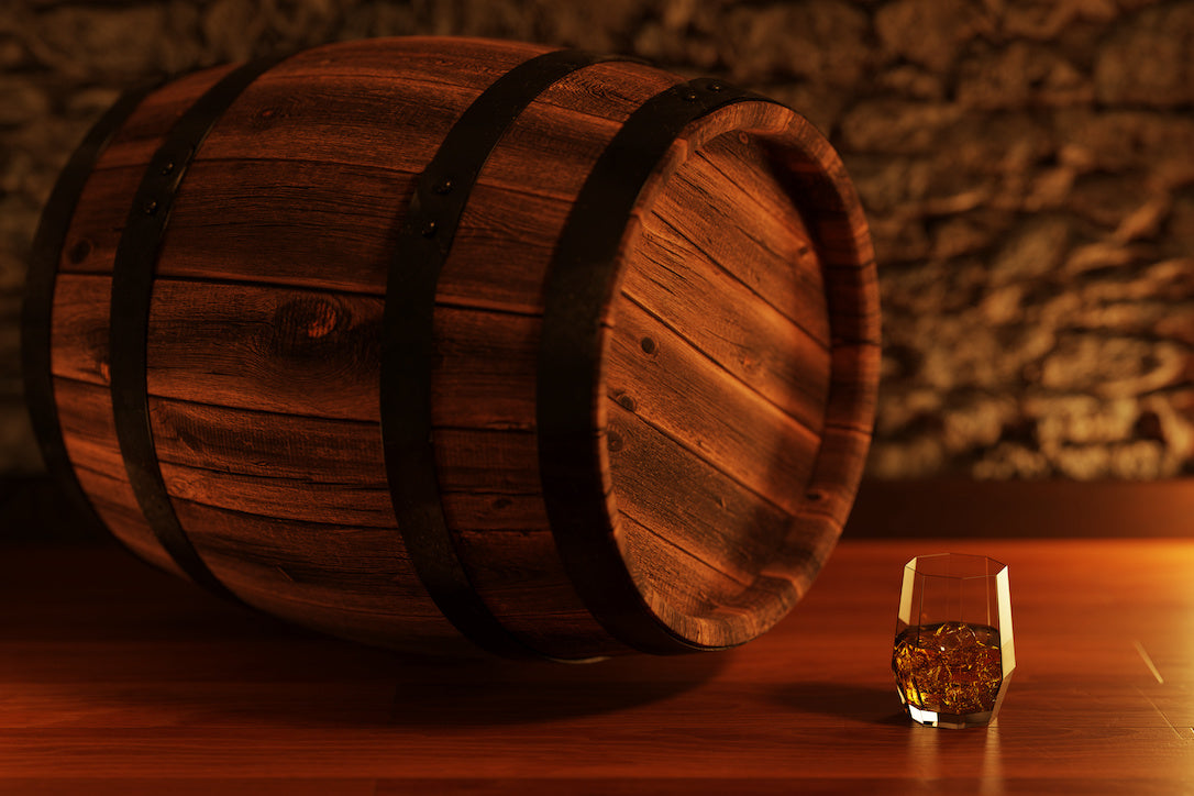 石レンガの壁の前にあるオーク樽とウイスキーのグラス