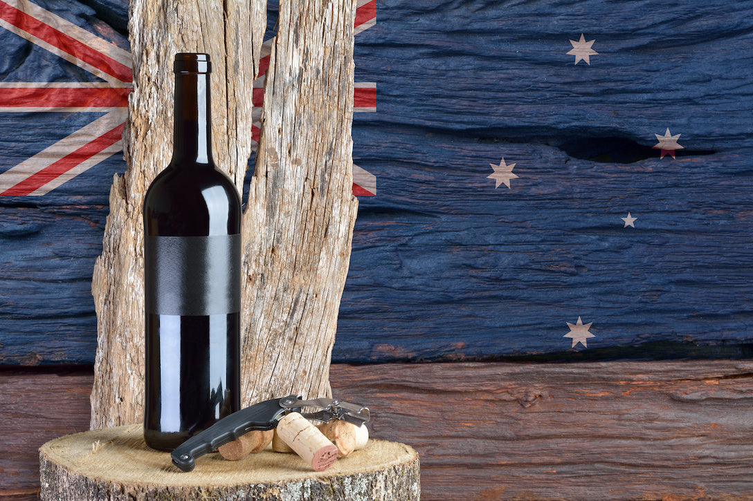 オーストラリアの国旗を背景に切り株に置かれたワインボトルとコルク抜き